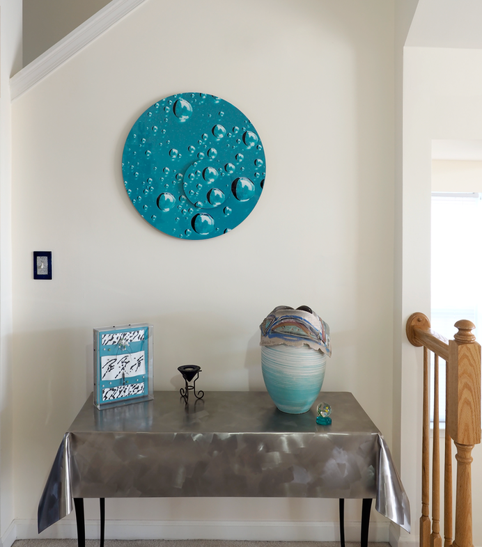 Round aluminum dimensional wall art showing water drops